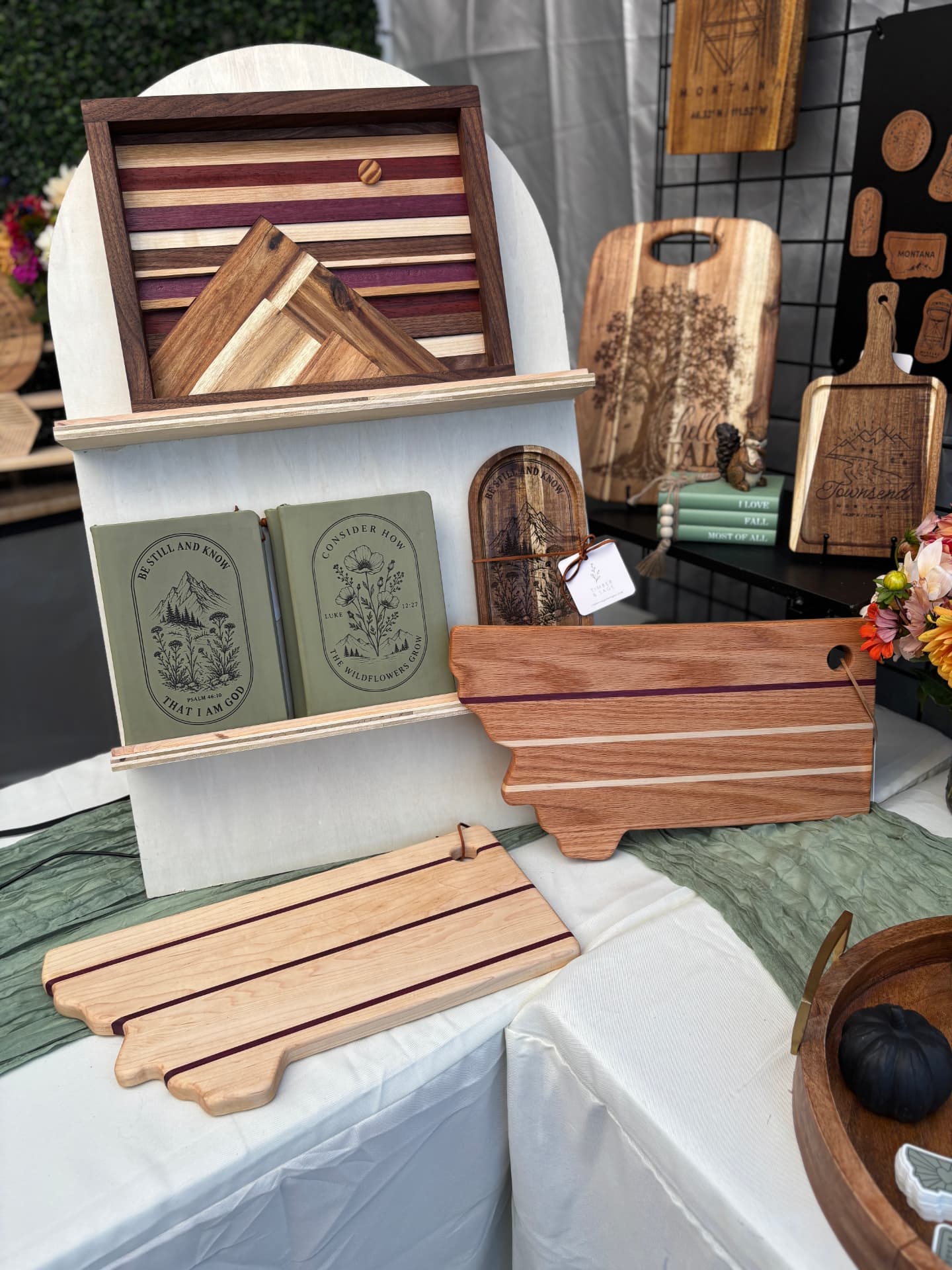 Timber & Sage booth display with engraved serving boards, keepsake boxes, and journals